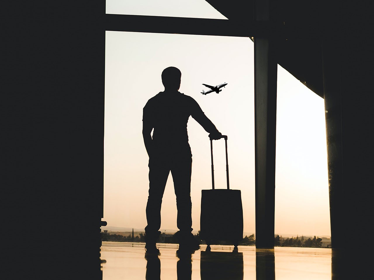 Un immigrant a l'aeroport contempla un avió allunyant-se